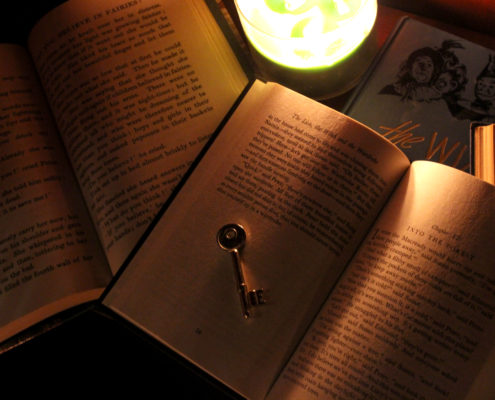 Open vintage books and a candle inside The Storykeeper