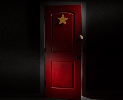A mysterious red door with a hand coming from within